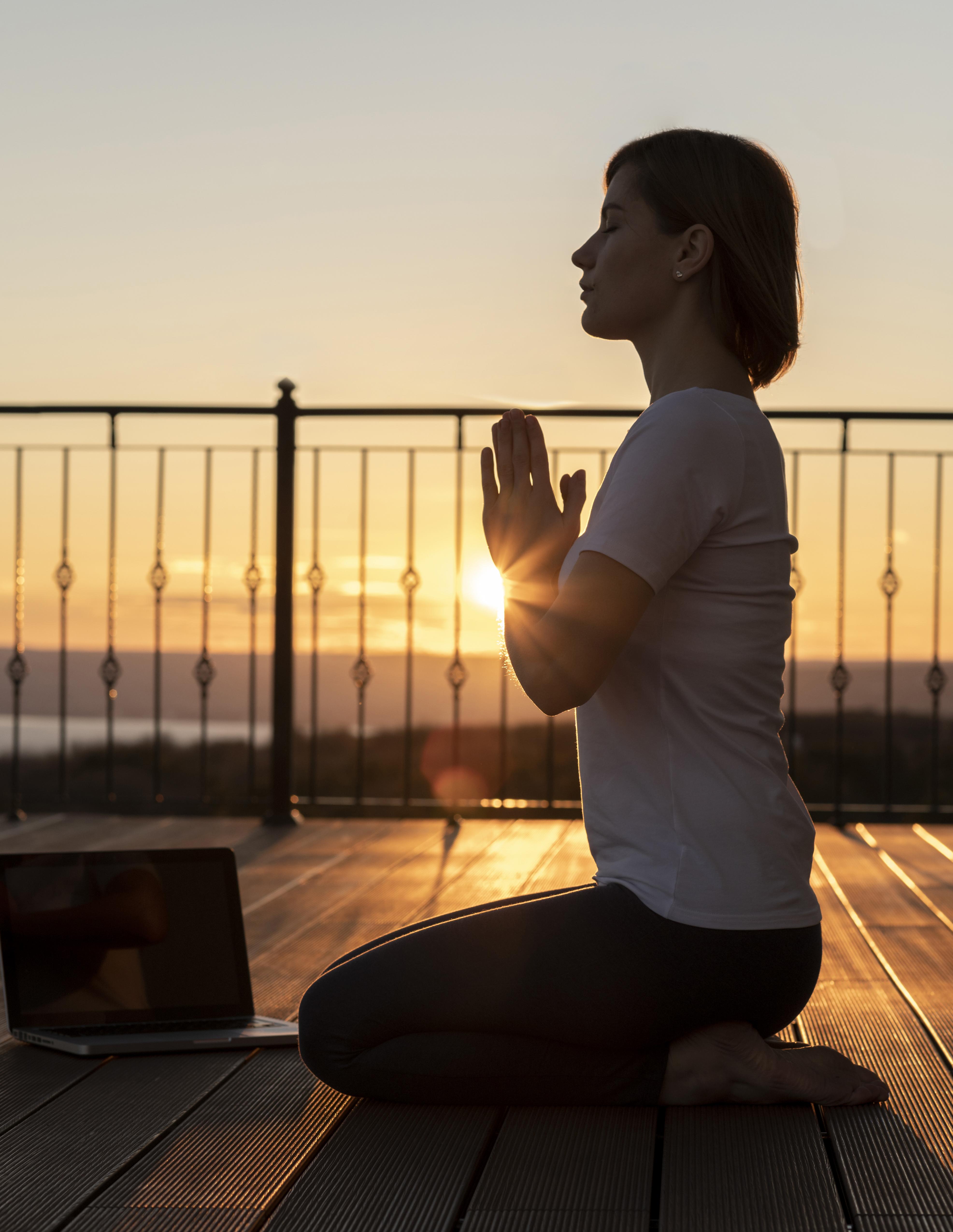 Meditaatioharjoitus järven rannalla auringonnousussa